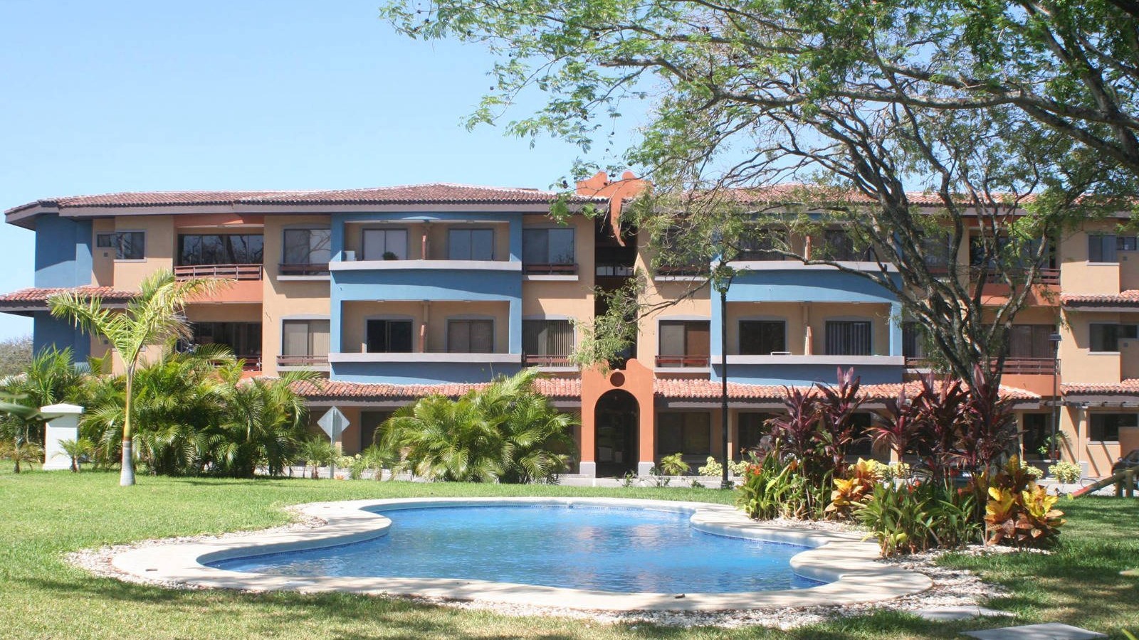 Multifamily architecture overlooking a pool and landscaped gardens
