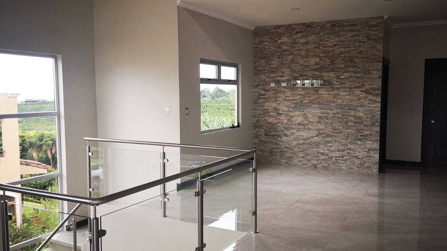 Stone feature wall and glass balustrade inside a CYME home